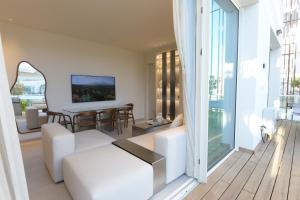 a living room with white furniture and a large window at Omega Pent House in Eilat
