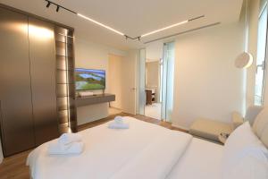 a bedroom with a white bed and a television at Omega Pent House in Eilat +44 photos