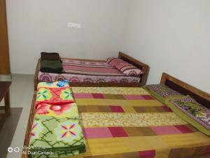 two beds are sitting in a room with sidx sidx sidx at Amrutha Easy Stay in Kalasa