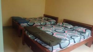 two twin beds in a room with at Amrutha Easy Stay in Kalasa
