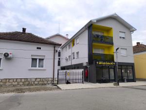 un edificio blanco y amarillo junto a una calle en Apartman Stefani, en Pirot