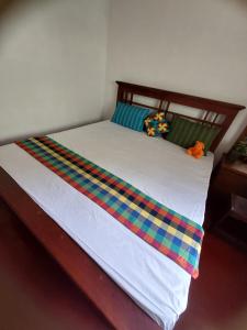a bed with colorful sheets and pillows on it at Golden Breeze Villa in Beruwala