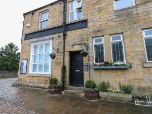 a stone house with a black door and windows at The Railway Apartment in Hexham