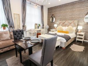 a bedroom with a bed and a table and a couch at The Railway Apartment in Hexham