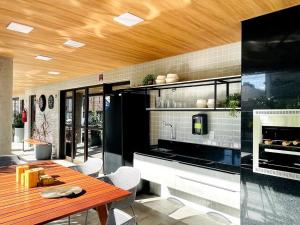 a kitchen with a wooden table and a dining room at Studio Design Mar in Maceió