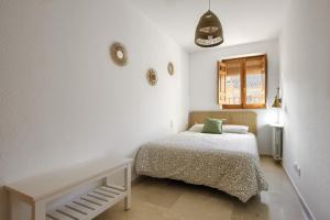 ein kleines Schlafzimmer mit einem Bett und einem Fenster in der Unterkunft Oliva y Limón - Acogedor Apartamento en Pedraza in Pedraza