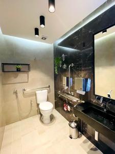 a bathroom with a toilet and a sink and a mirror at Studio Design Mar in Maceió