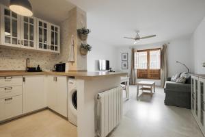 eine Küche mit weißen Schränken und einer Waschmaschine und einem Trockner in der Unterkunft Oliva y Limón - Acogedor Apartamento en Pedraza in Pedraza