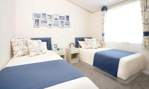 a bedroom with two beds and a window at The Lakes Rookley Holiday Park in Rookley +69 photos