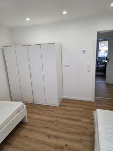 a bedroom with white cabinets and a wooden floor at Monteurzimmer im Zentrum von Kaiserslautern in Kaiserslautern +1 photo