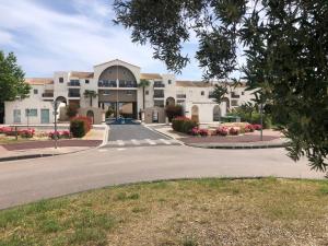 a large building with a road in front of it at Résidence L'écume in Saint-Cyprien-Plage