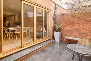 a patio with a table and chairs and a brick wall at Host & Stay - Aurora in Deal