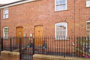 a brick building with two doors and a fence at Host & Stay - Aurora in Deal