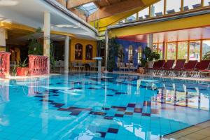 a large swimming pool with blue tiles in a building at Kohlerhof - 4 Star Wellness & Active Hotel in Fügen +65 photos
