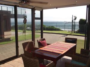 Un patio con mesa y sillas y vista al mar. en Luuks, en Victoria Bay