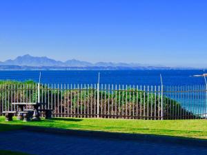 una valla con una mesa de picnic frente al agua en Luuks, en Victoria Bay 3 fotos más
