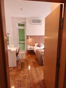 a bedroom with a bed and a desk and a sink at Noviz Hotel in Plovdiv