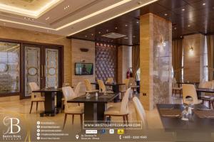 a restaurant with tables and chairs in a room at Bristol Hotel Salalah in Salalah