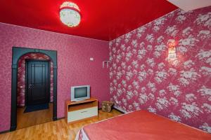 
a bedroom with a red wall and a red wall clock at Baza otdyha Dikiy Ray in Verkhniy Is
