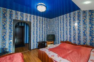 
a bedroom with a red bed and a blue wall at Baza otdyha Dikiy Ray in Verkhniy Is
