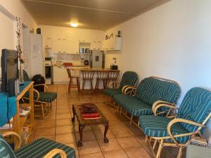 a living room with chairs and a table and a kitchen at Bay view sea cottage in Victoria Bay