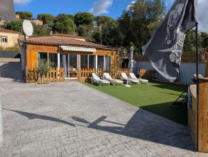Un patio con sillas blancas y una gran bandera. en Casa M&D, en Lloret de Mar