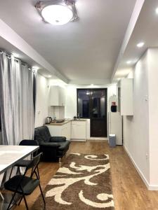 a living room with a table and a kitchen at Apartament cu Terasă și Vedere la Apus in Voluntari