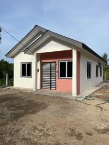 a small house with a red door at Homestay Bajet Kg Telaga Mas Paka in Paka