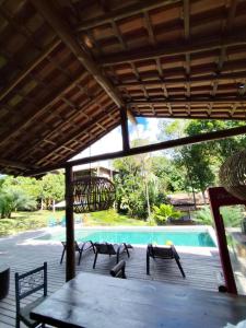 a patio with a table and chairs next to a pool at Casa Gabriela-Confort and Exclusivity in Trancoso in Porto Seguro