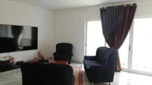 a living room with two chairs and a flat screen tv at Sal Blue Apartment in Santa Maria