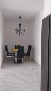a dining room with a table and chairs and a chandelier at Sal Blue Apartment in Santa Maria +7 photos