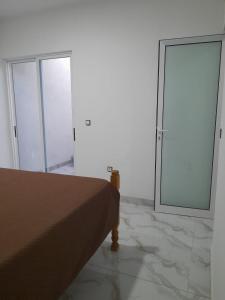 a bedroom with a bed and two sliding glass doors at Sal Blue Apartment in Santa Maria