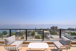 a balcony with two chairs and a table at Levication Premium Private Jacuzzi Apartments in Tiberias
