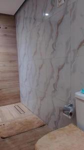 a bathroom with a marble wall with a toilet at Sal Blue Apartment in Santa Maria
