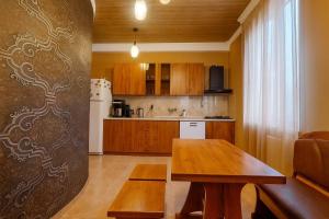 a kitchen with a wooden table in a room at VILLA SABA WITH TWO BEDROOMS- სასტუმრო საბა in Mtskheta