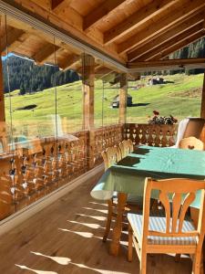 a dining room with a green table and chairs at Sertig Ferienwohnung in Davos