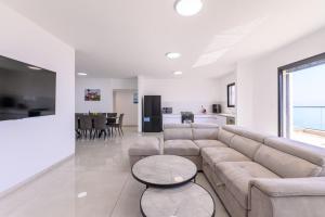 a large living room with a couch and a kitchen at Levication Premium Private Jacuzzi Apartments in Tiberias