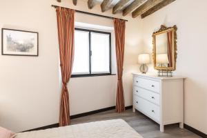 a bedroom with a window and a dresser and a mirror at La Casa Di Fiore in Genova