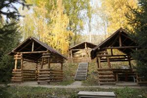 Dos grandes estructuras de madera con escaleras en un bosque. en Hills Hotel, en Karakol