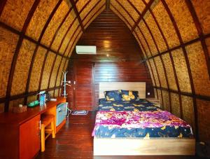 ein Schlafzimmer mit einem Bett in einem kleinen Zimmer in der Unterkunft Villa RR Senggigi in Senggigi 