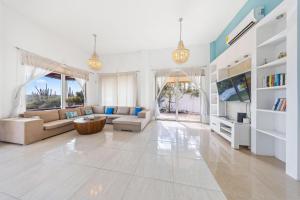 a living room with a couch and a tv at Beautiful 5BR Villa *Zen*Nature*Views*BBQ*BathTub* in Noord