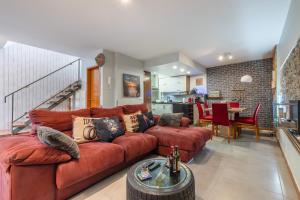 a living room with a brown leather couch at Sissi Lanço View 7 in Santa Luzia