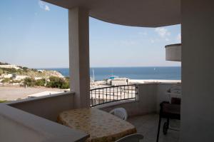 a balcony with a table and a view of the beach at La Celestina in Castro di Lecce