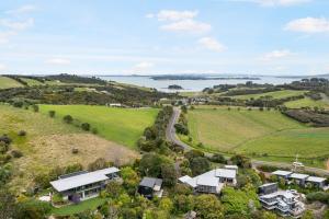 une vue aérienne sur une ferme avec une route et des maisons dans l'établissement Floriana on Church - Oneroa, à Waiheke Island