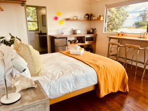 une chambre avec un grand lit et une cuisine dans l'établissement Floriana on Church - Oneroa, à Waiheke Island