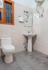 a bathroom with a toilet and a sink at The Woods View I Vacations I Family Groups & Events I Forest Treks I Memories Toy Train View I Serviced Apartments I Kasauli By Exotic Stays in Kasauli +45 photos
