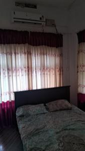 a bedroom with a bed in front of curtains at Sea view villa 3 in Kāsaragod
