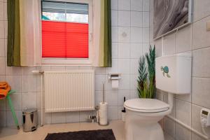 Un baño con inodoro blanco y ventana. en Gemütliche Wohnung in der Nähe von Gmunden, en Ohlsdorf 13 fotos más