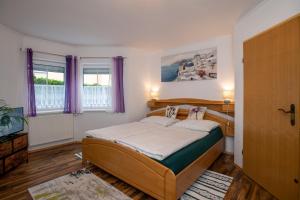 1 dormitorio con 1 cama y 2 ventanas con cortinas moradas en Gemütliche Wohnung in der Nähe von Gmunden, en Ohlsdorf