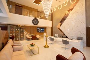 a lobby with a couch and chairs and a clock at The Grand Sanvika in Ramakkalmedu